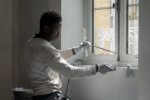 Peintre Cité Portrait d'un peintre travaillant les menuiseries d'une fenêtre